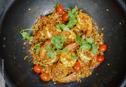 Close up Thai deep fried shrimps with garlic cherry tomatoes and coriander on a pan, Top view of deep fried shrimps with garlic photo