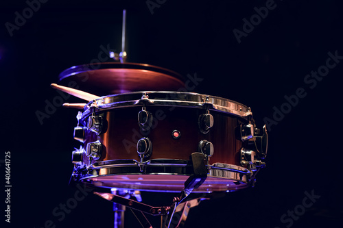 Snare drum and drumsticks close up in dark.