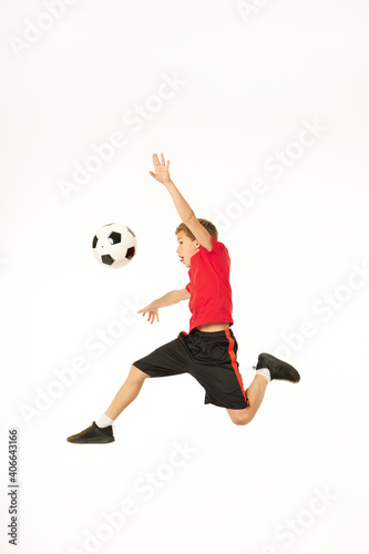 Adorable male child jumping and playing football