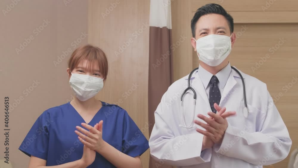Portrait of Asian doctor and nurse clapping hands, looking at camera. Portrait of Asian doctor and nurse clapping hands, looking at camera.