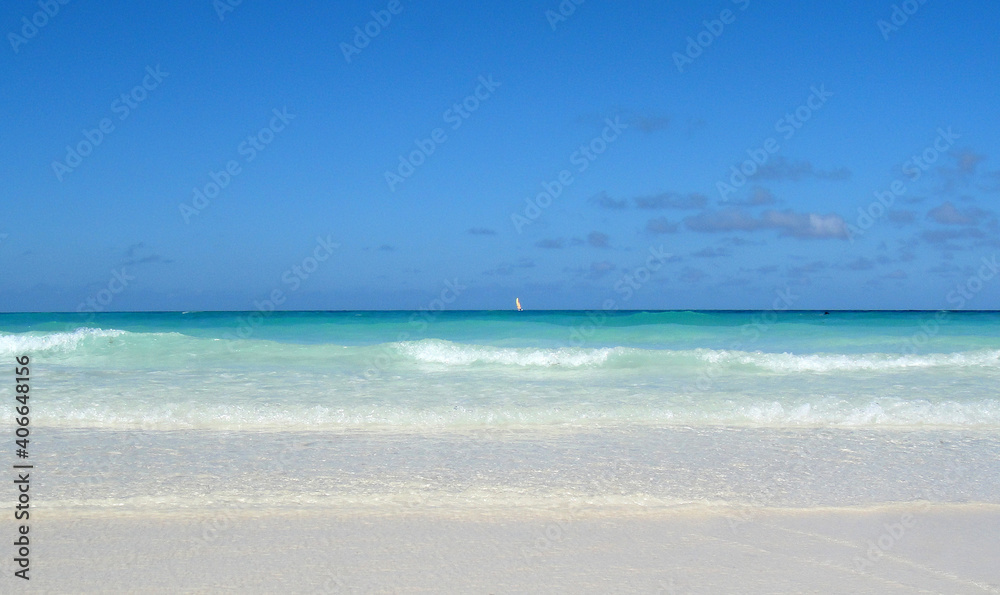 Sailboat at the Atlantic Ocean gliding over the wave ocean surface.Turquoise water view from powder white sandy beach. Sailboat at the Atlantic Ocean gliding over the wave ocean surface.Turquoise water view from powder white sandy beach.