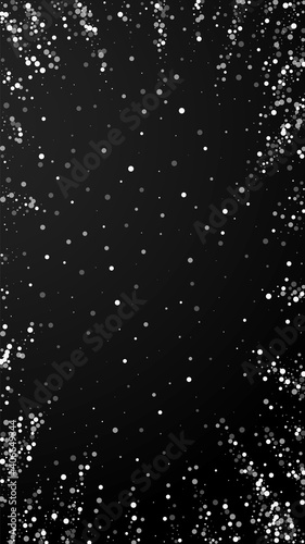 Random white dots Christmas background. Subtle flying snow flakes and stars on black background. Actual winter silver snowflake overlay template. Brilliant vertical illustration.