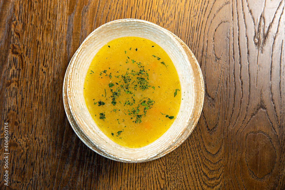 Chicken soup served on a wooden table, top view Chicken soup served on a wooden table, top view