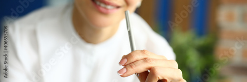 Woman in white shirt hold pen with hand close up and smile. Sign and fill out document in office.