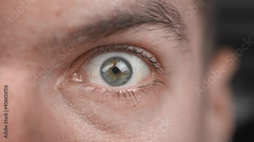 Extreme close up of surprised male opens his eye wide and stares at the camera. Scared man shock reaction macro eye.