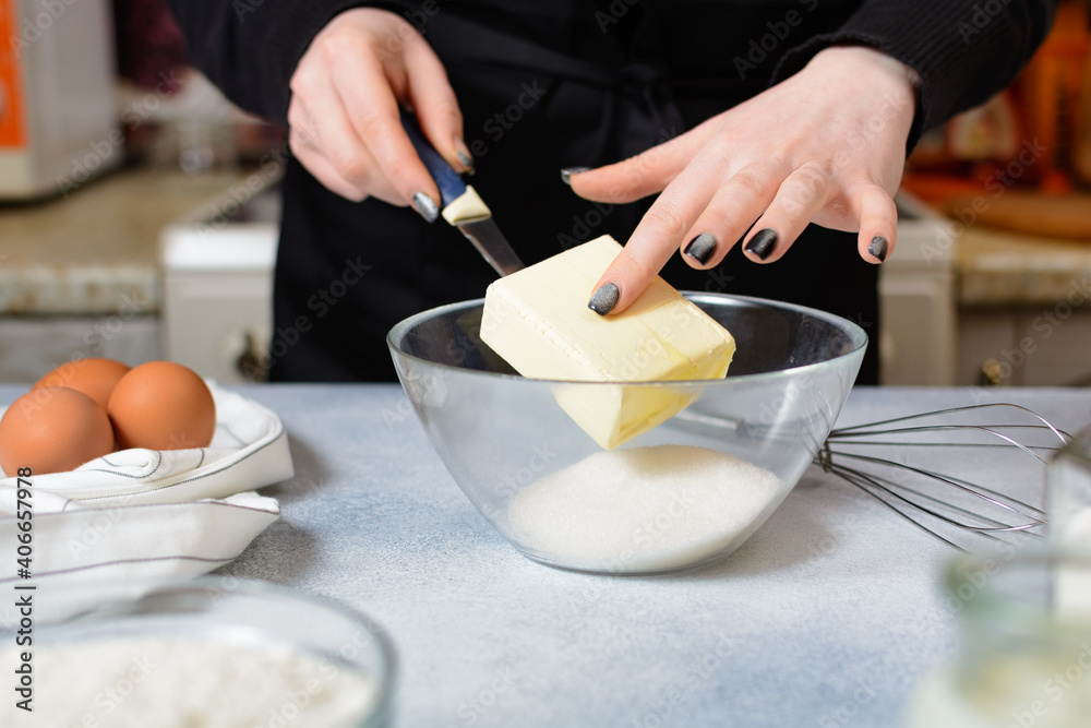 the cook puts a piece of butter in a bowl with sugar the cook puts a piece of butter in a bowl with sugar