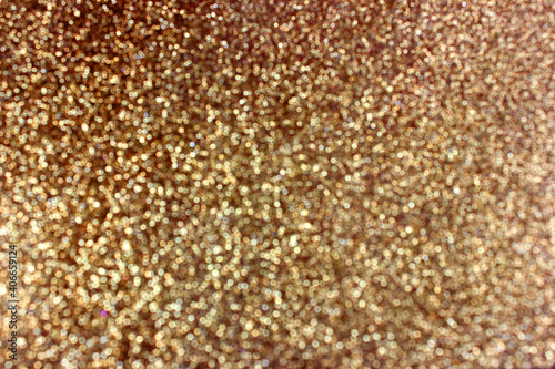 Abstract gold glitter and shimmer background with bokeh effect. Background for festive design, new year and christmas. Stock photography. 