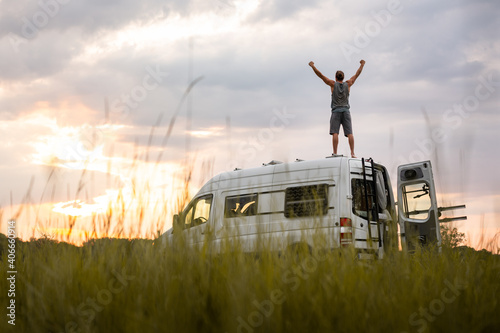 Fényképezés Man with raised arms on top of his camper van