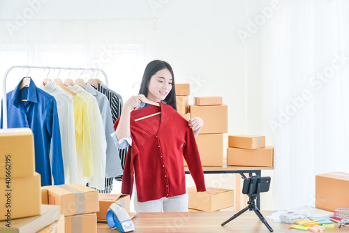 Young Asian girl selling clothes online by live streaming. Online selling ,live streaming Concept.