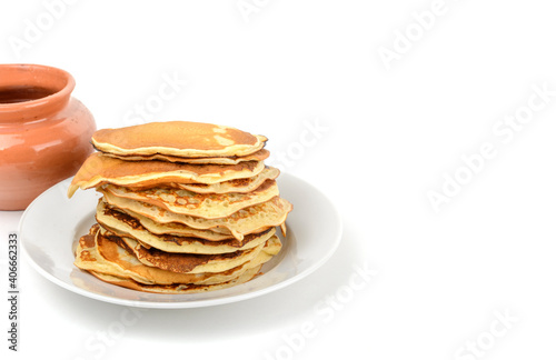 Breakfast.A stack of pancakes in a plate and a pot of honey on a white isolated background.Free space.Space for text, horizontal view.