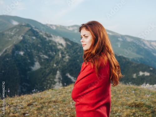 Romantic woman hiding behind a red plaid in the mountains outdoors in nature © SHOTPRIME STUDIO