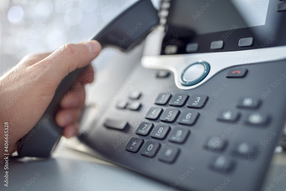 Dialing a telephone in the office concept for communication, contact us and customer service support Dialing a telephone in the office concept for communication, contact us and customer service support
