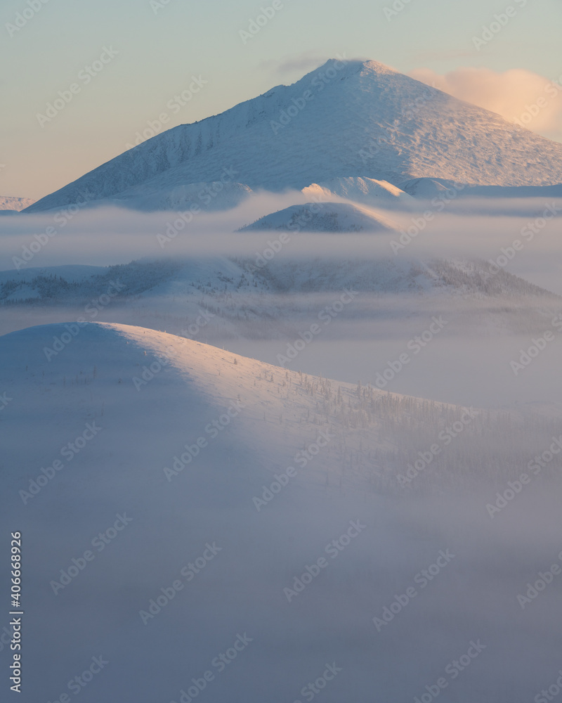Fog on the Olchansky pass in the Oymyakonsky district. Morning landscape of snow-capped mountains. Foggy landscape of the coldest place on Earth - Oymyakon Fog on the Olchansky pass in the Oymyakonsky district. Morning landscape of snow-capped mountains. Foggy landscape of the coldest place on Earth - Oymyakon