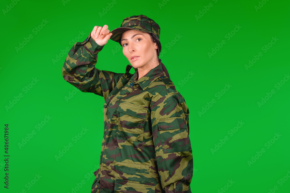 Portrait of a serious strong military woman on a green background with blank space. The concept of gender inclusivity in force army