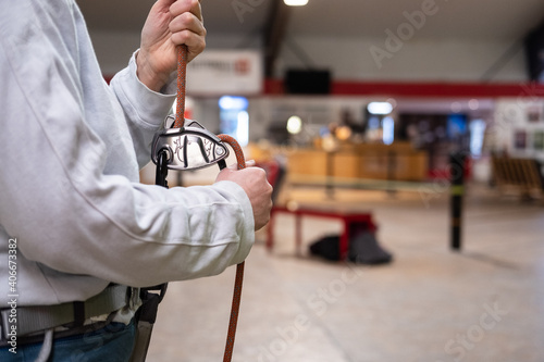 Eine Person hält ein Seil zur Sicherung in einer Kletterhalle photo