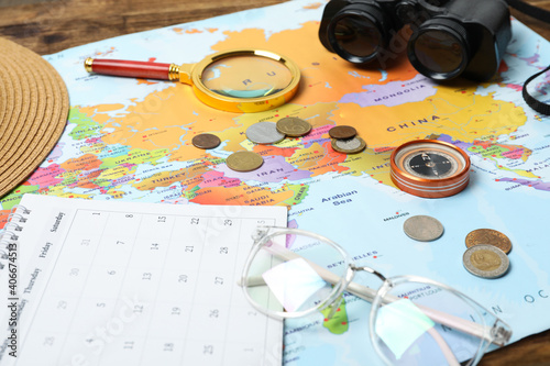 Different travel accessories and world map on table, closeup. Planning summer vacation trip