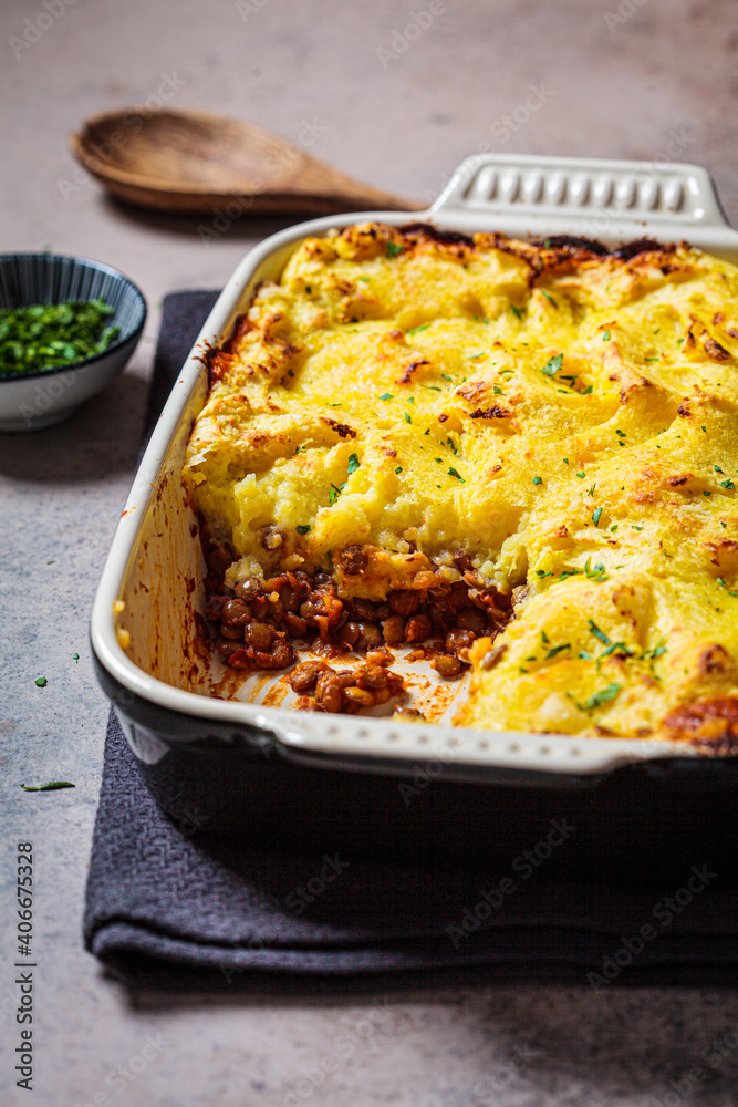 Vegan shepherd's pie with lentils and mashed potatoes in black backing dish. Vegan healthy food concept. Vegan shepherd's pie with lentils and mashed potatoes in black backing dish. Vegan healthy food concept.