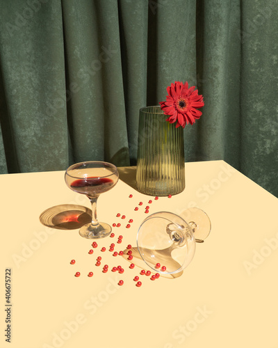 Vintage scene with vine glasses, red flower in green retro vase and red pearls on bright sandy table. Retro Valentines day party concept.