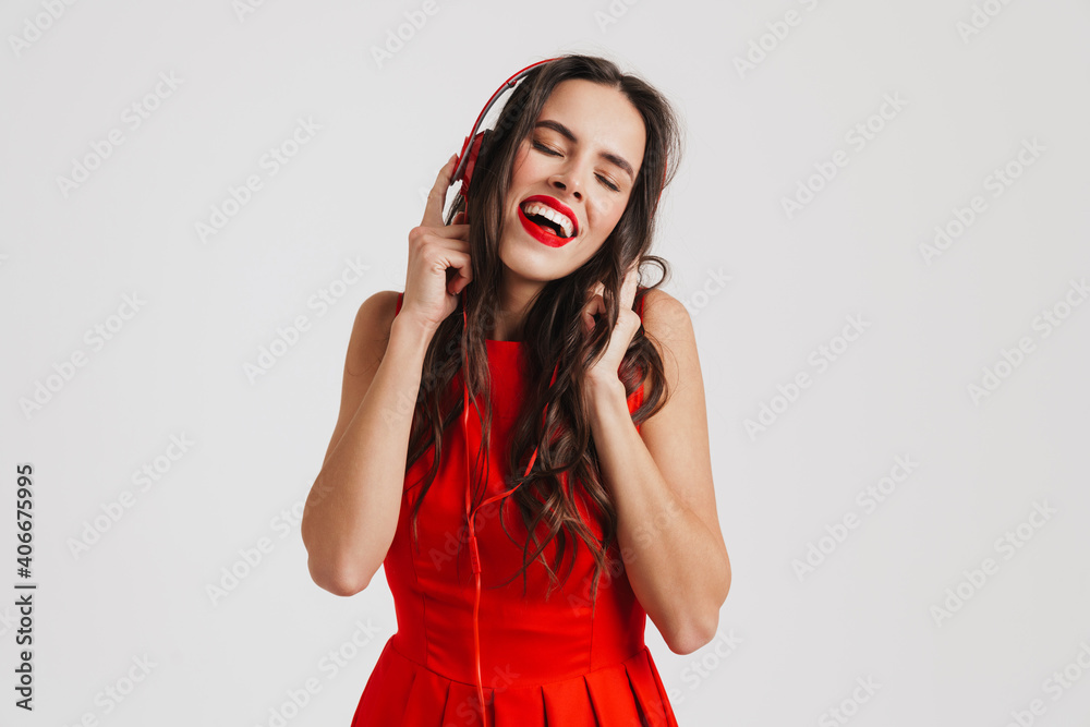 Obraz premium Happy beautiful brunette girl listening music with headphones