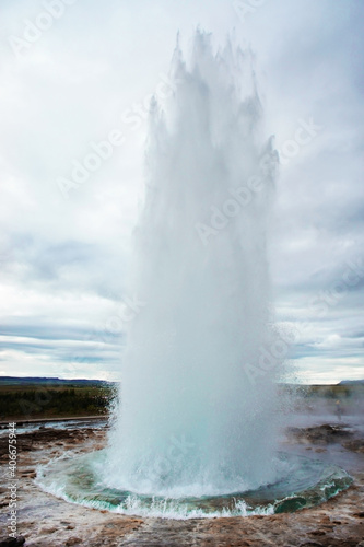 The Great Geysir, geyser in southwestern Iceland, Haukadalur valley, Geyser splashing out of the ground against the background of a cloudy sky, abstract vertical background with water