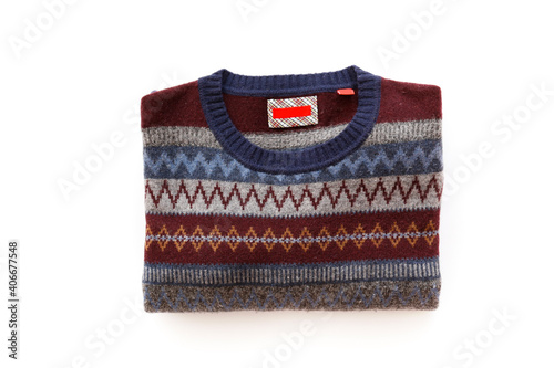Top view shot of sweater with different knitting patterns, stripes, rhombus and zigzag isolated on white background. Close up, copy space, flat lay.
