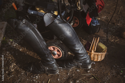 Black riding boots with other riding equipment