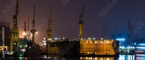 SHIPYARD - A floating repair dock and port cranes on the wharves