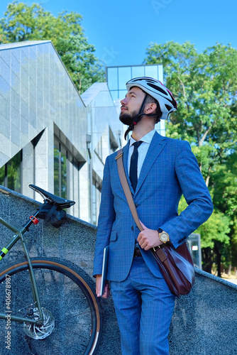Bearded businessman in helmet with bicycle.