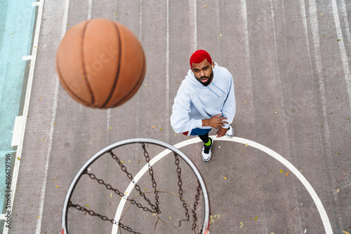 Bearded african american guy playing basketball at playground outdoors © Drobot Dean