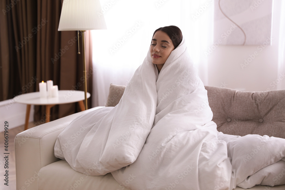 Woman wrapped in blanket resting on sofa Woman wrapped in blanket resting on sofa