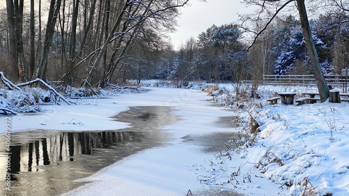 zimowy krajobraz częściowo zamarzniętej rzeki koło Włodawy dużo śniegu niebieskie niebo złota godzina 