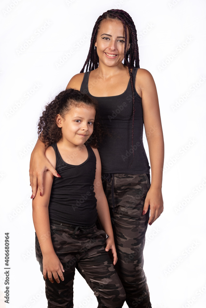 Mother and daughter dressed alike in a very happy rehearsal, white background, selective focus. Mother and daughter dressed alike in a very happy rehearsal, white background, selective focus.