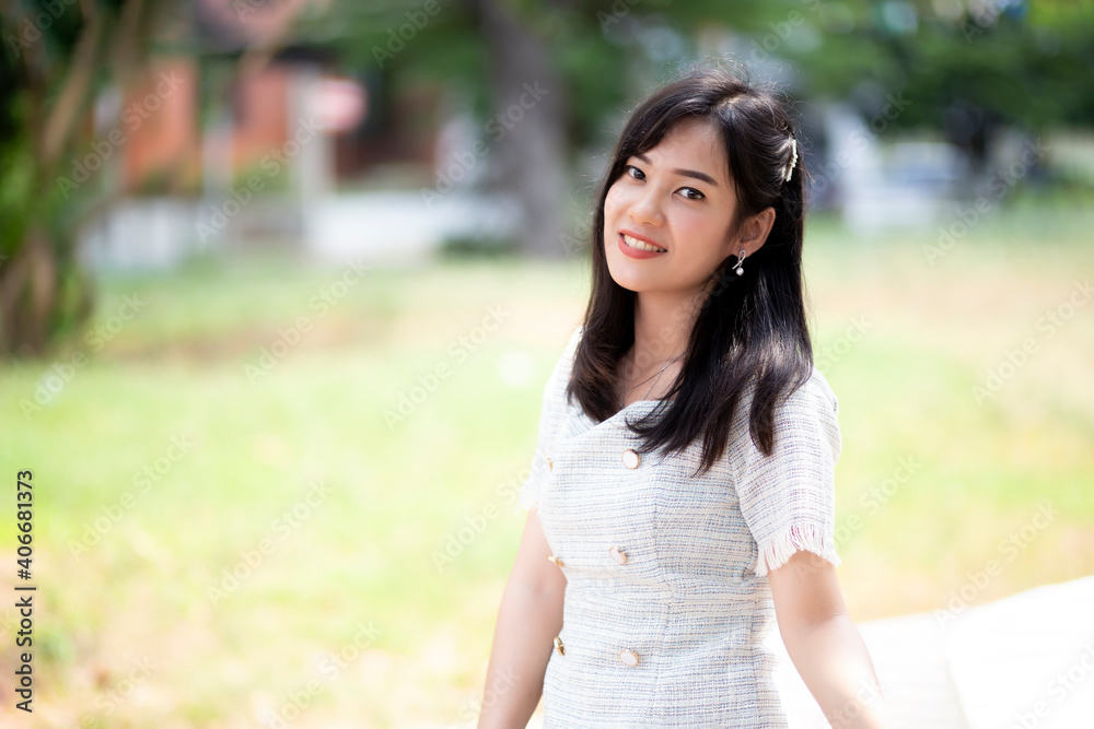 Portrait of asian women sitting in the garden with green tree background. A beautiful woman smiling and looking at the camera. Portrait of asian women sitting in the garden with green tree background. A beautiful woman smiling and looking at the camera.
