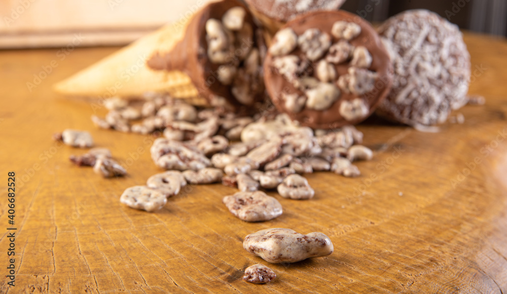 Sweet, ice cream cone filled with chocolate and cream with chocolate flakes, on rustic wood, selective focus. Sweet, ice cream cone filled with chocolate and cream with chocolate flakes, on rustic wood, selective focus.