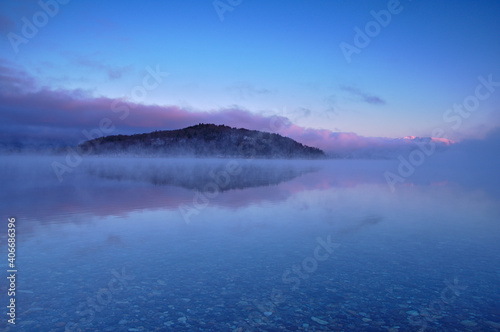 湖面に朝靄の漂う早朝の湖。氷点下の朝の屈斜路湖。阿寒摩周国立公園。北海道、日本。 © Masa Tsuchiya