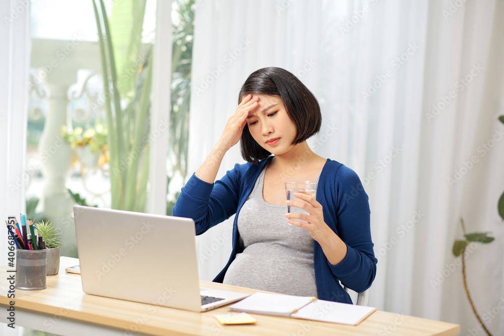 Young pregnant woman suffering from headache at home Young pregnant woman suffering from headache at home