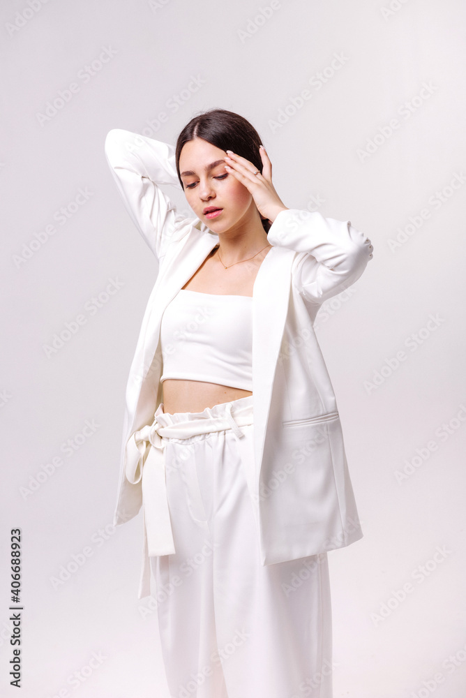 Fashion portrait of a beautiful brunette in white eco clothes on a white background