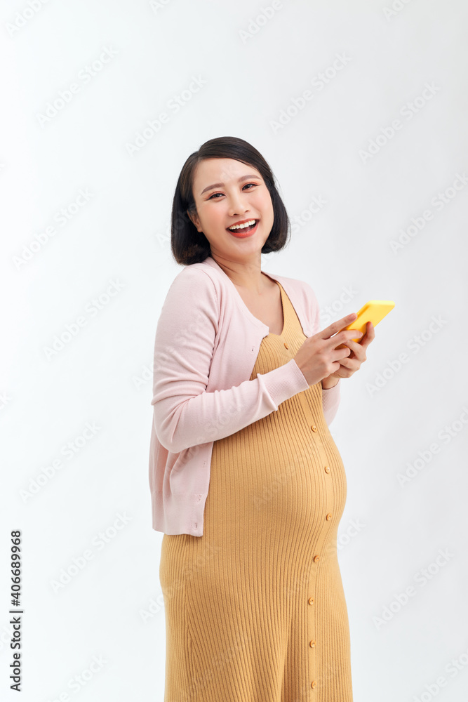 Portrait of a smiling cute pregnant woman using mobile phone isolated on a white background Portrait of a smiling cute pregnant woman using mobile phone isolated on a white background