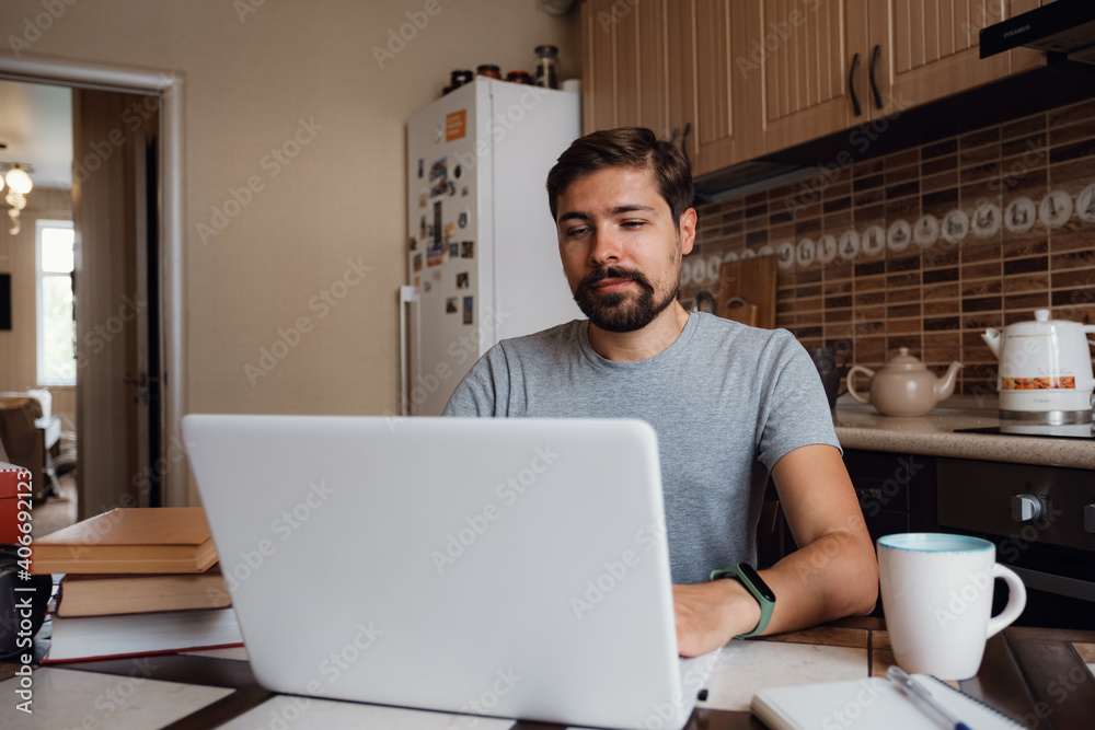 young man freelancer using laptop studying online or working young man freelancer using laptop studying online or working