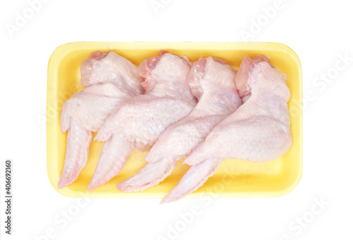 Raw Chicken wings in a yellow polystyrene container isolated on white background. Four fresh chicken parts for cooking. Top view.