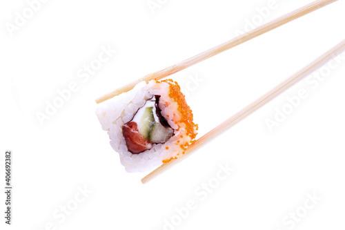 One sushi roll in chopsticks isolated on white background. Classic roll with salmon, cucumber and cheese. Traditional Japanese cuisine. Close up.