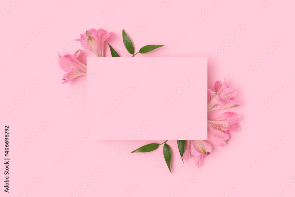 Fototapeta premium Border frame made of alstroemeria flower on a pink pastel background. Paper sheet mockup. Greeting card for 8 March or Mothers Day.
