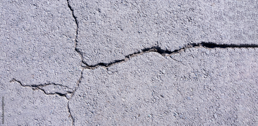 Fototapeta premium old concrete pavement with cracks and natural destruction from time and weather conditions