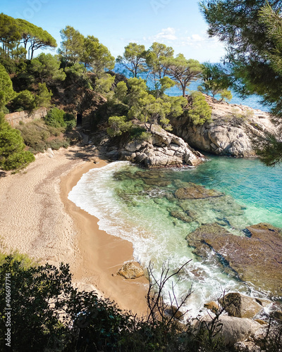 Beautiful beach in Costa brava, Spain, in the coast of Catalonia during summer. Surrounded by rocks and pine trees and with turquoise water.