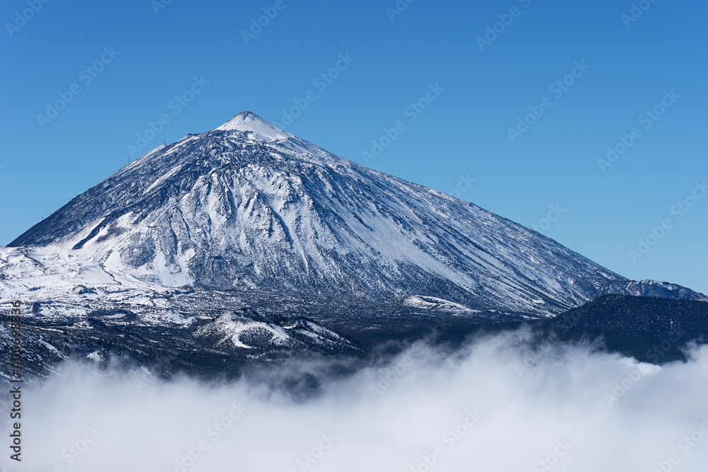 Pico del Teide mountain volcano in snow, bright blue sky. Teide National Park, Tenerife, Canary Islands, Spain. Pico del Teide mountain volcano in snow, bright blue sky. Teide National Park, Tenerife, Canary Islands, Spain.