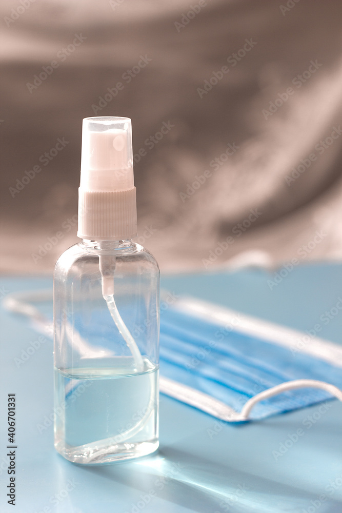 Sanitizer spray in a plastic bottle and a medical mask, a new reality precautions during the quarantine and coronavirus pandemic Sanitizer spray in a plastic bottle and a medical mask, a new reality precautions during the quarantine and coronavirus pandemic