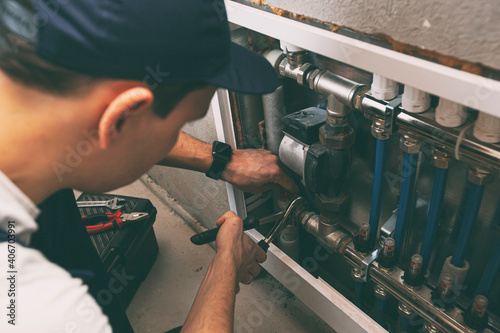 Принти на полотні The man is installing the heater system in the house