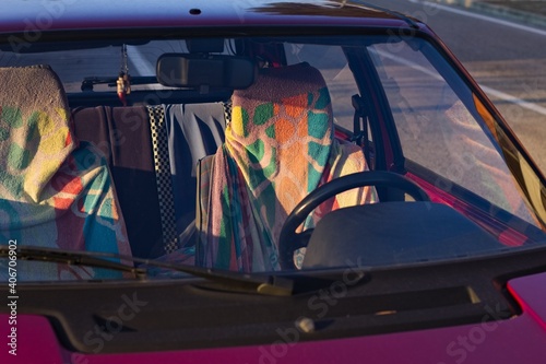 The seats of a red vintage car covered in colorful towels (Marche, Italy, Europe)