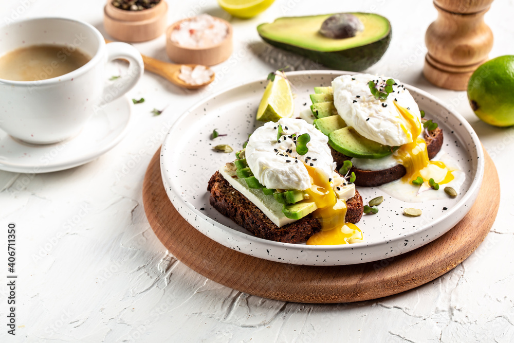 Sandwich with avocado and Poached Egg. Wholemeal Bread Toast sliced avocado and egg with cup of coffee for healthy breakfast or snack, copy space