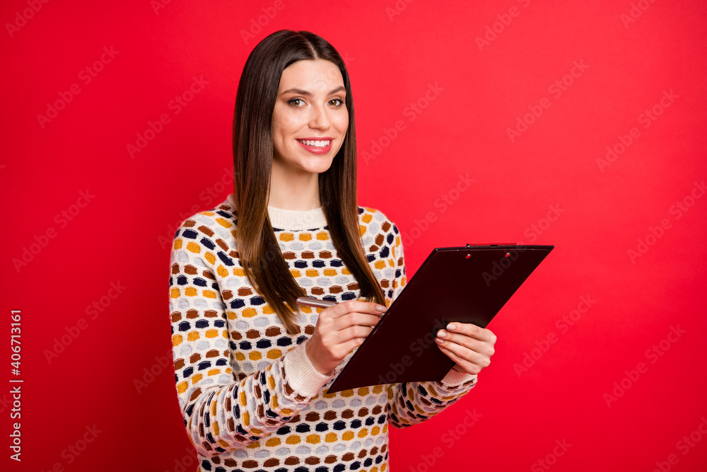 Portrait of optimistic nice girl write paper wear colorful sweater isolated on red color background Portrait of optimistic nice girl write paper wear colorful sweater isolated on red color background